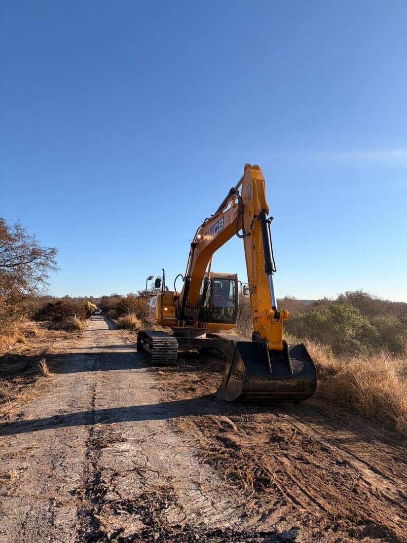 Retroexcavadora avanzando por el camino de la traza