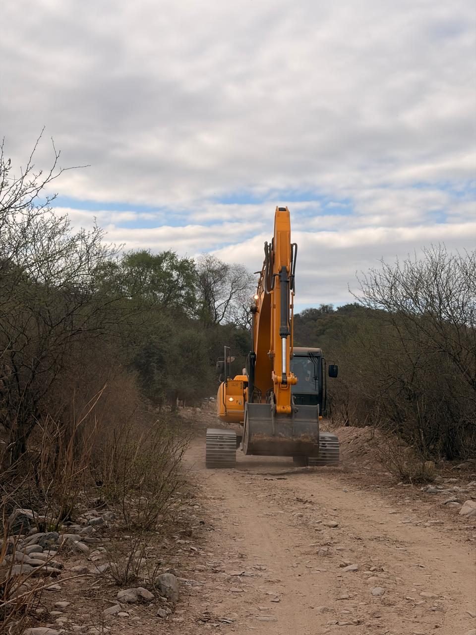 Retroexcavadora JCB avanzando por la pista abierta hacia la Toma del Río Vipos